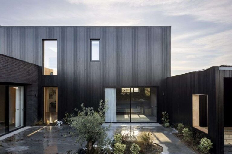 siyah metal dış cephesi ve büyük minimalist pencereleri olan modern ev