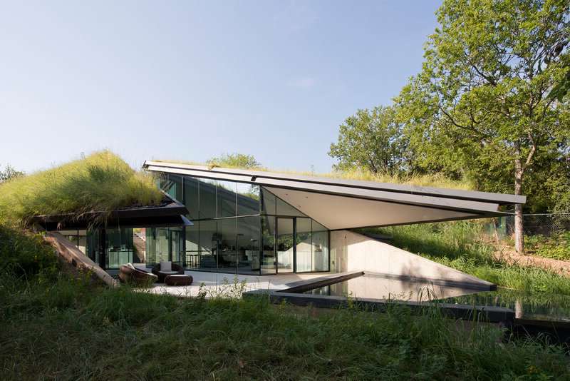yeşil çatılı, cam duvarlı ve havuzlu bahçeli kır evi